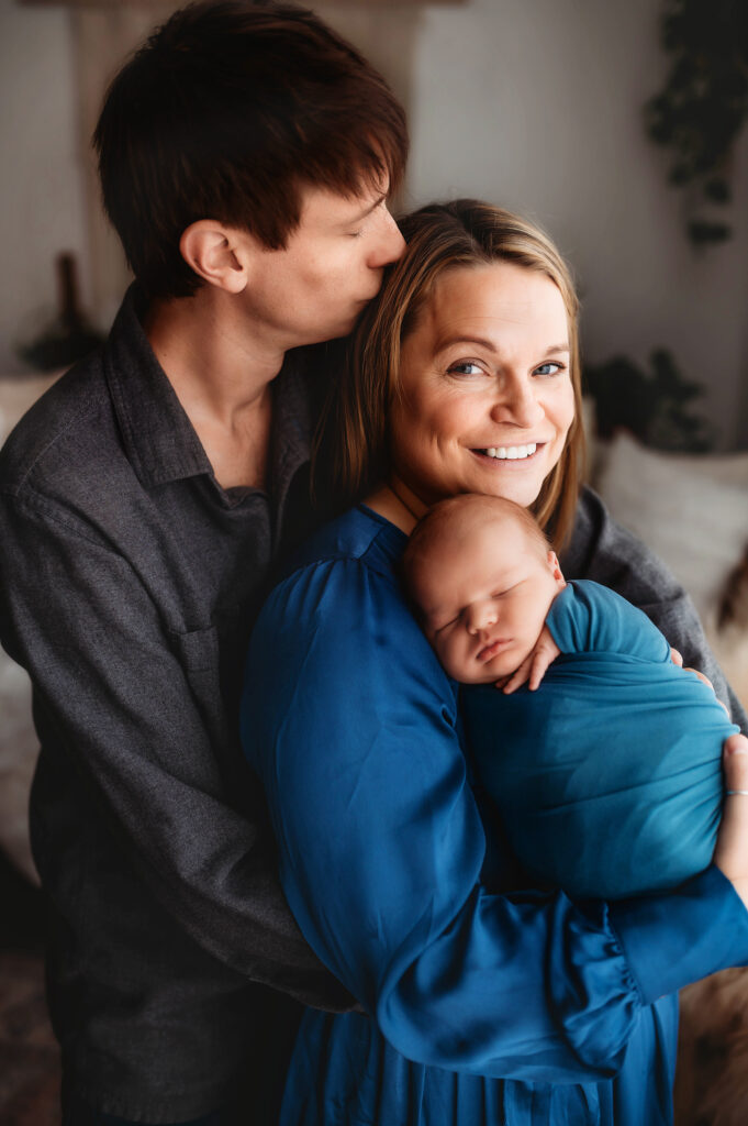 New parents embrace their infant during Newborn Portraits in Charleston, SC. 
