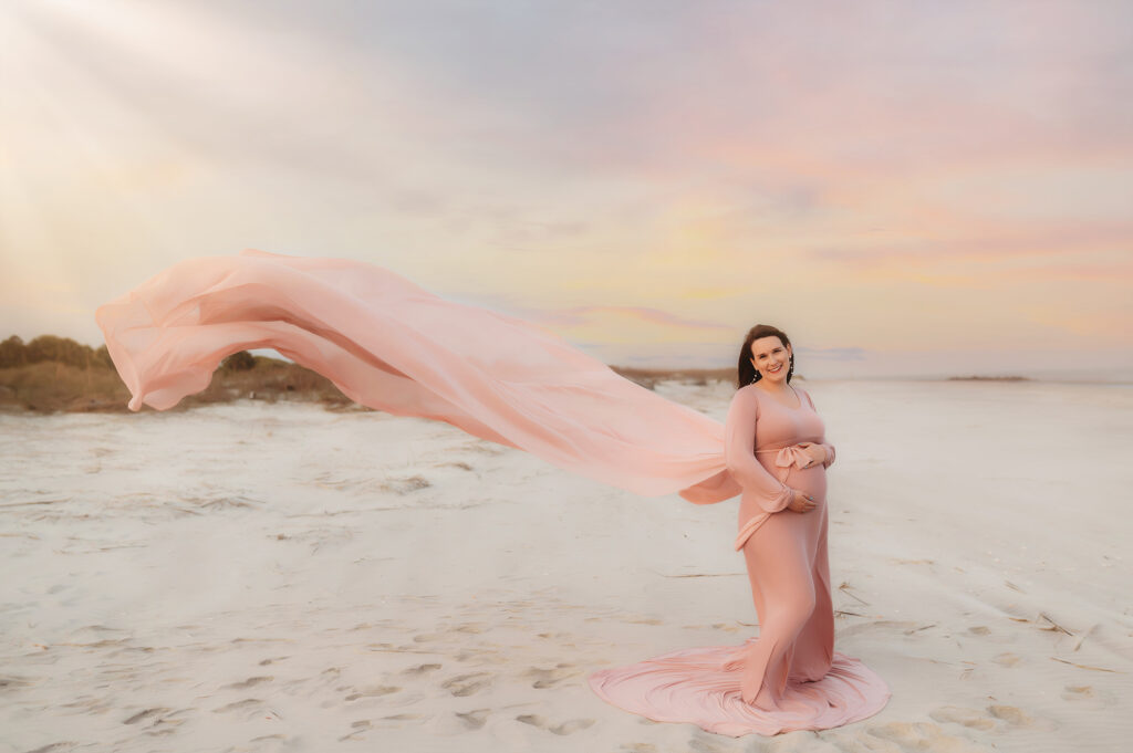 Pregnant woman poses for Maternity Photoshoot on Folly Beach in Charleston, South Carolina after researching Top Ten Ideas for Planning your Babymoon in Charleston.