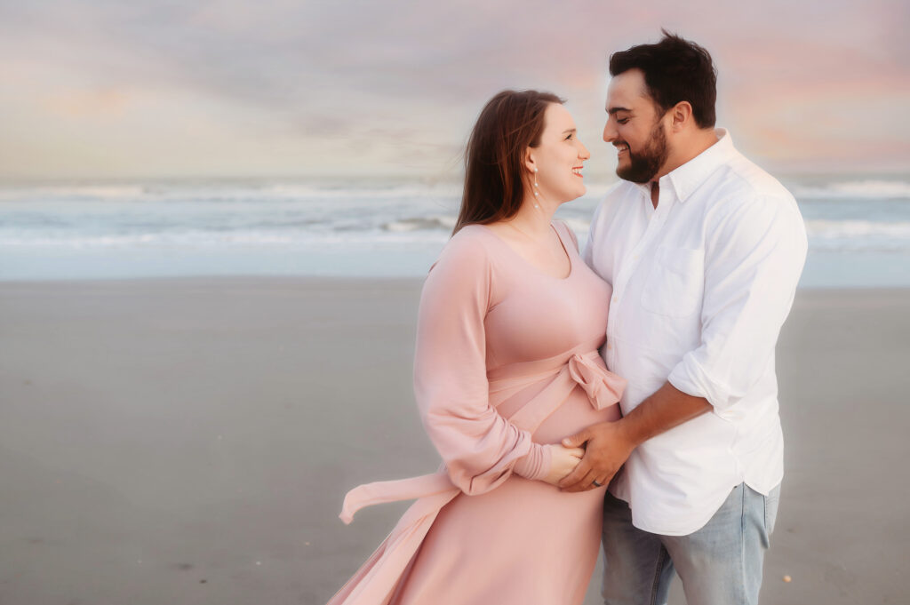 Expectant parents pose for Maternity Photoshoot on Folly Beach in Charleston, South Carolina after researching Top Ten Ideas for Planning your Babymoon in Charleston.