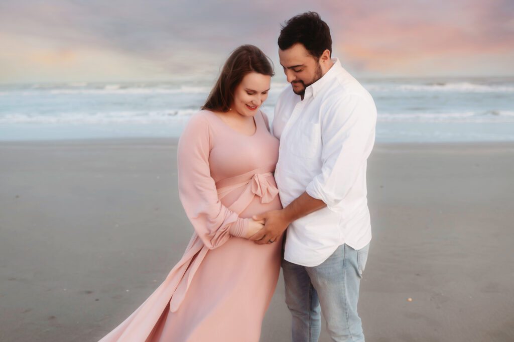 Expectant parents pose for Maternity Photoshoot on Folly Beach in Charleston, South Carolina after researching Top Ten Ideas for Planning your Babymoon in Charleston.