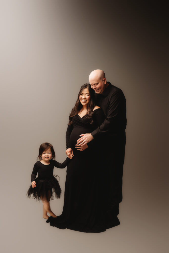 Expectant parents pose for Studio Maternity Portraits with their toddler in Charleston, SC 