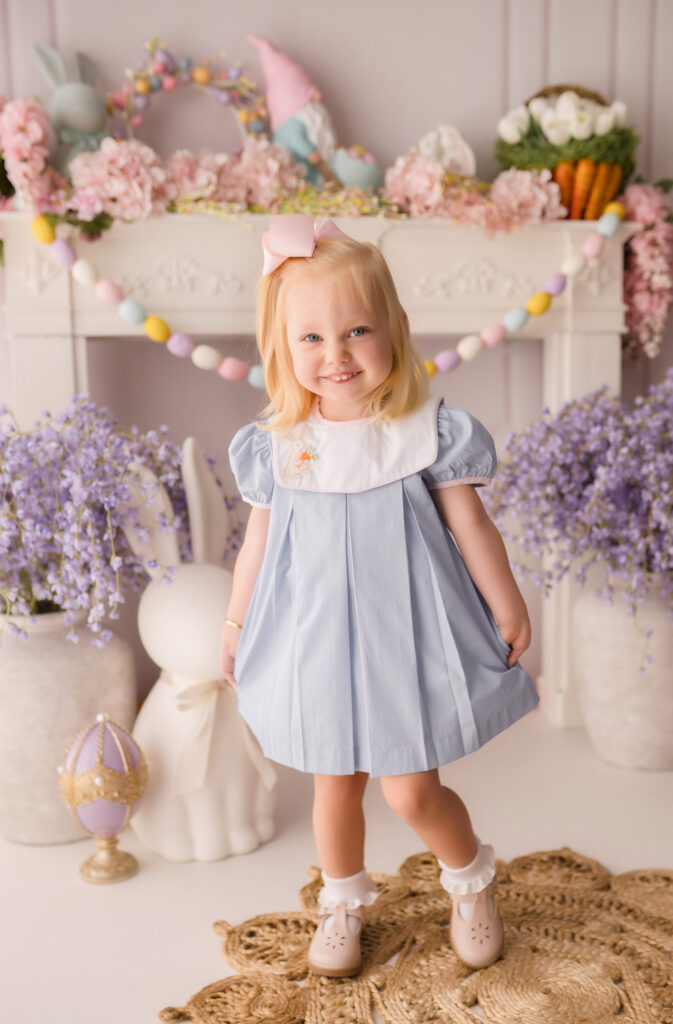 Little girl smiles at the camera during Easter Mini Session at Holy City Babies Portrait Studio in Charleston, SC. 