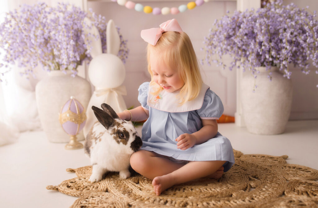 Little girl pets a live bunny during Easter Mini Session at Holy City Babies Portrait Studio in Charleston, SC. 