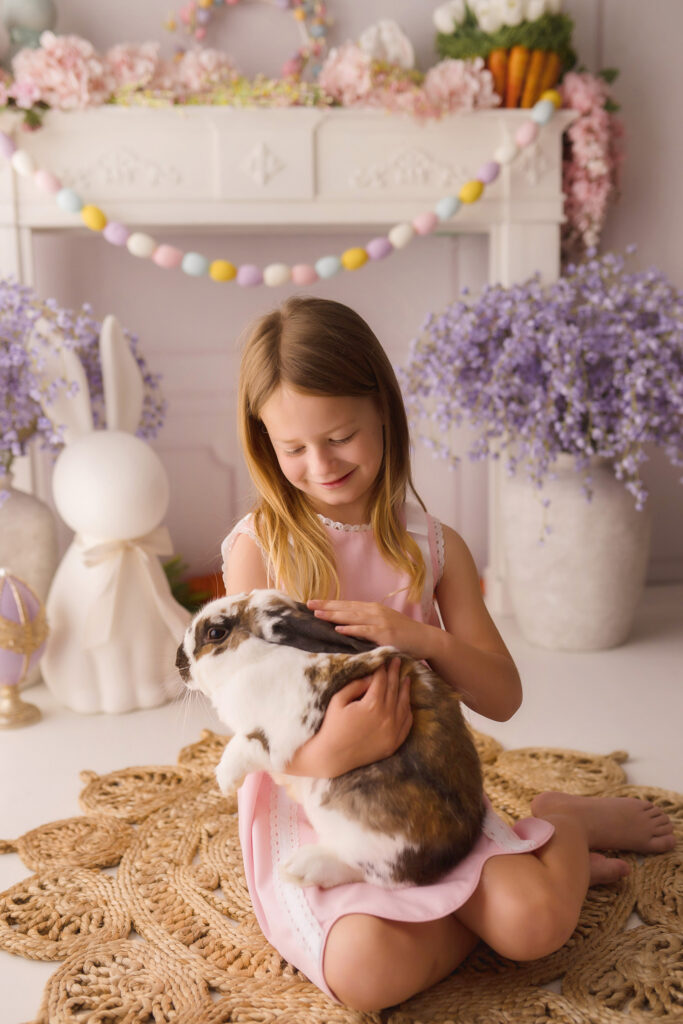 Little girl pets a live bunny  during Easter Mini Session at Holy City Babies Portrait Studio in Charleston, SC. 