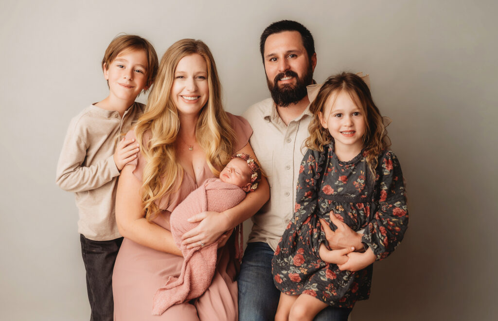 Family poses together for Newborn Portrait Session at Holy City Babies Portrait Studio in Charleston, SC.
