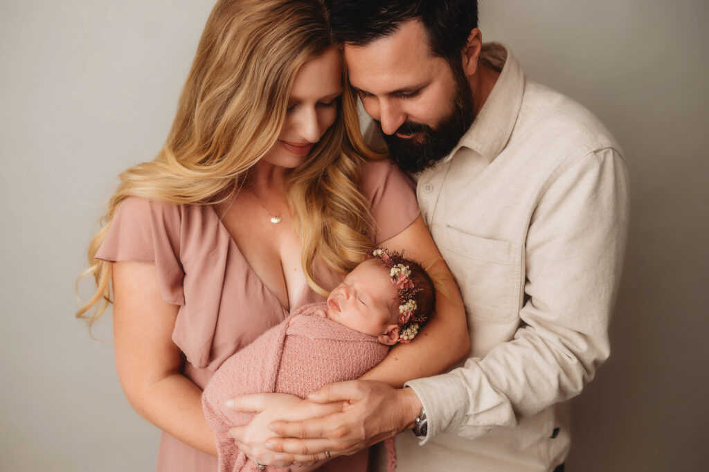 Parents embrace their Infant during Newborn Portraits at Holy City Babies Portrait Studio in Charleston, SC.