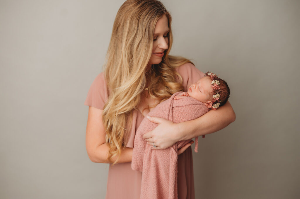 Mother embraces her newborn baby during Newborn Portrait Session at Holy City Babies Portrait Studio in Charleston, SC.
