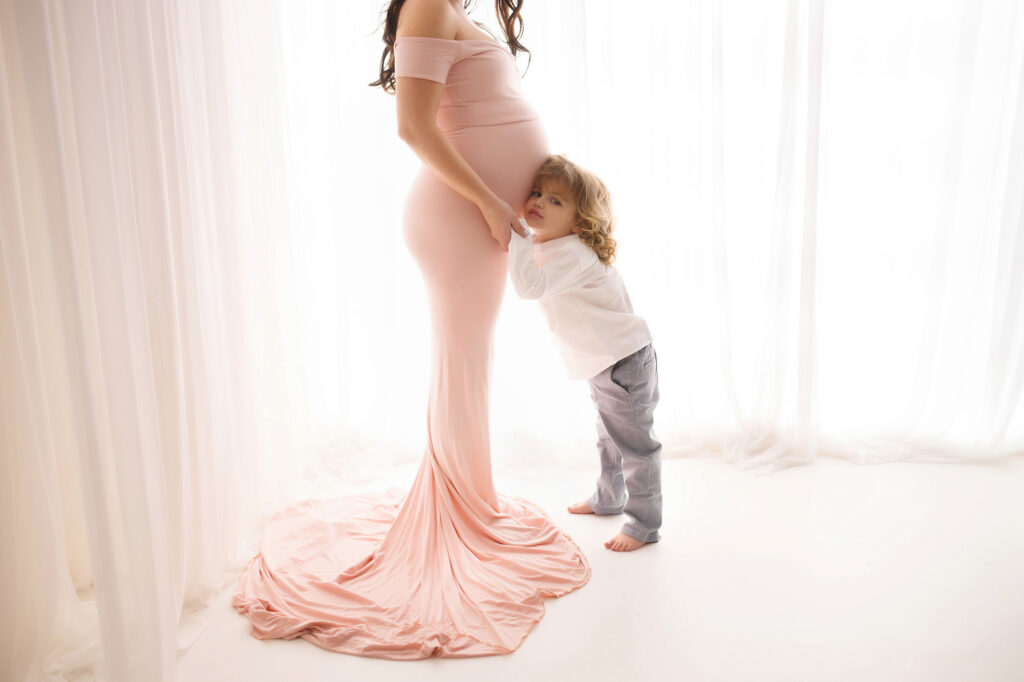 Expectant mom poses with her toddler during Maternity Photoshoot at Holy City Babies Portrait Studio in Charleston, SC. 