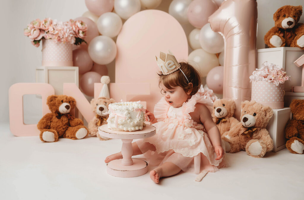 Charleston Cake Smash Photography - baby peers at the camera during a studio Milestone Portrait Session at Holy City Babies Portrait Studio in Charleston, SC. 