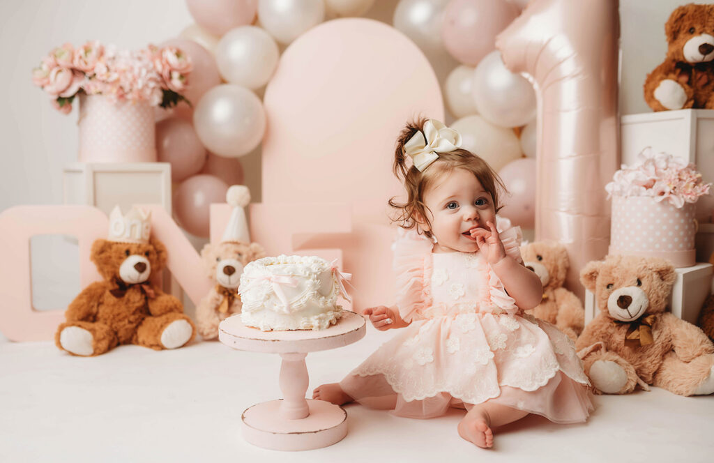 Charleston Cake Smash Photography - baby peers at the camera during a studio Milestone Portrait Session at Holy City Babies Portrait Studio in Charleston, SC. 