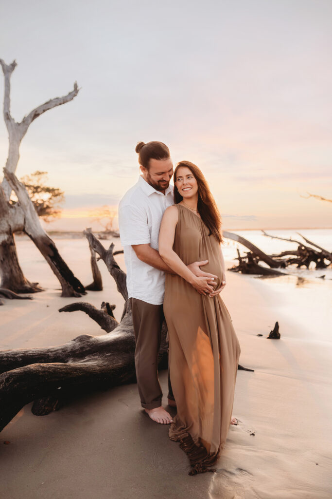 Expectant Parents pose for Maternity Photos on Folly beach in Charleston, SC.
