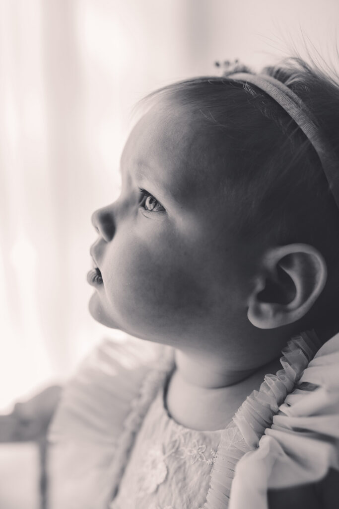 Baby looks to their parent during their First Birthday, Milestone, Cake Smash Photoshoot at Holy City Babies Portrait Studio in Charleston, SC.