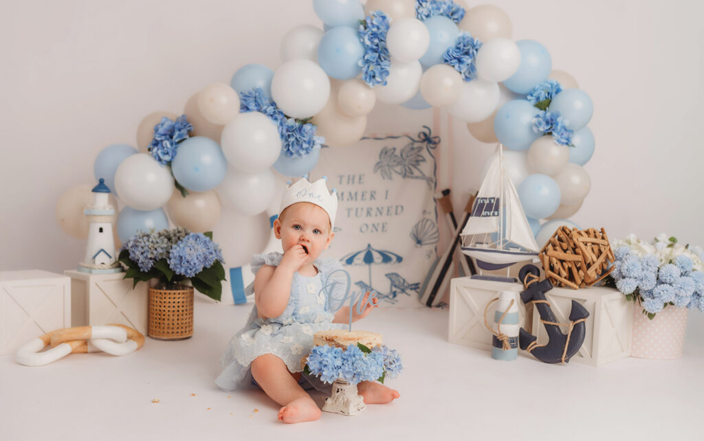 Luxury First Birthday Photography in Charleston - Baby peers at the camera during their First Birthday, Milestone, Cake Smash Photoshoot at Holy City Babies Portrait Studio in Charleston, SC.