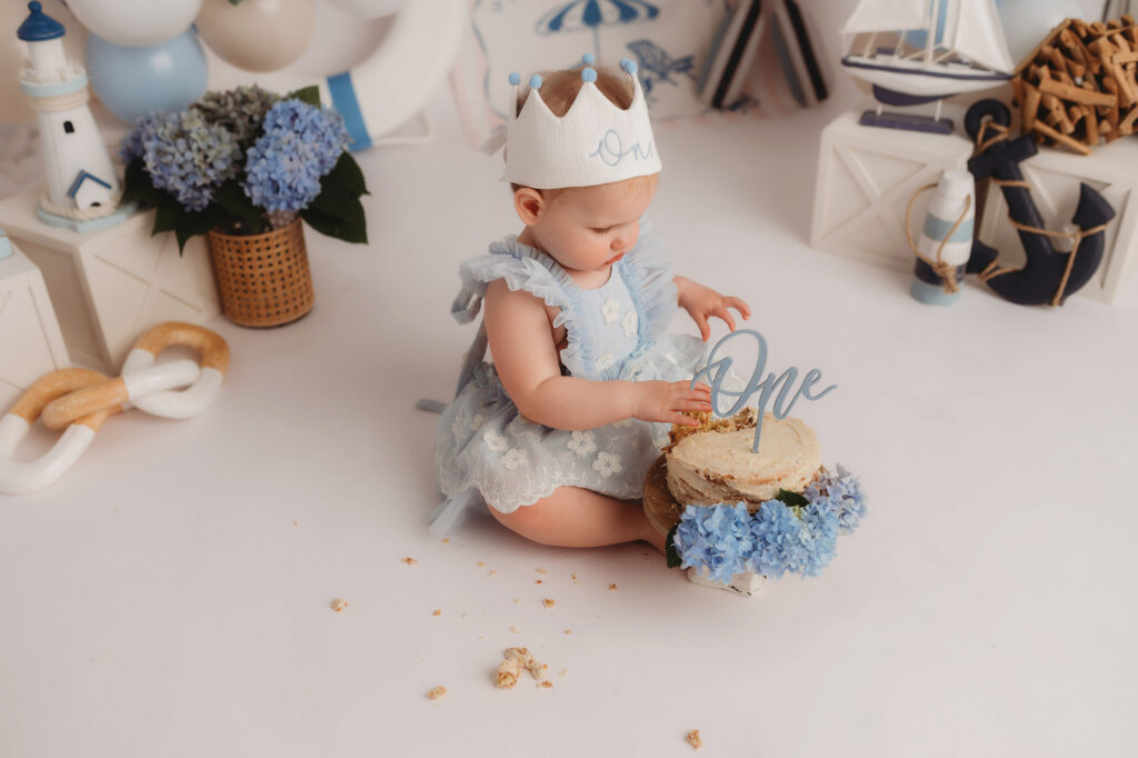 Baby celebrates first birthday with a Milestone, First Birthday Cake Smash Photoshoot at Holy City Babies Portrait Studio in Charleston, SC.