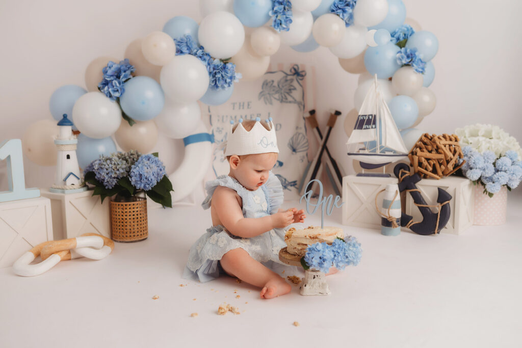 Baby enjoys smash cake during their First Birthday, Milestone, Cake Smash Photoshoot at Holy City Babies Portrait Studio in Charleston, SC.