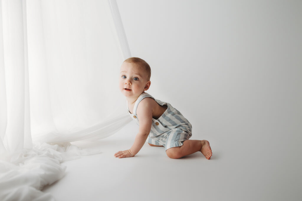 Baby celebrates first birthday with a Milestone, First Birthday Cake Smash Photoshoot at Holy City Babies Portrait Studio in Charleston, SC.
