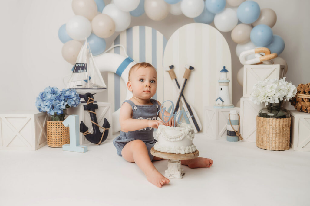 Baby celebrates first birthday with a Milestone, First Birthday Cake Smash Photoshoot at Holy City Babies Portrait Studio in Charleston, SC.