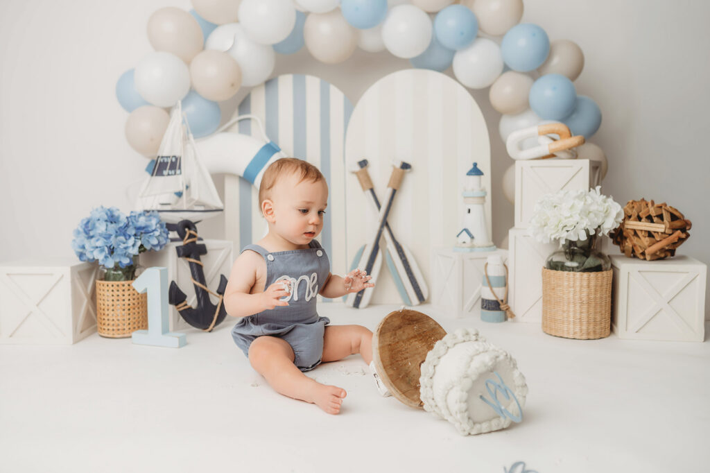 Baby celebrates first birthday with a Milestone, First Birthday Cake Smash Photoshoot at Holy City Babies Portrait Studio in Charleston, SC.
