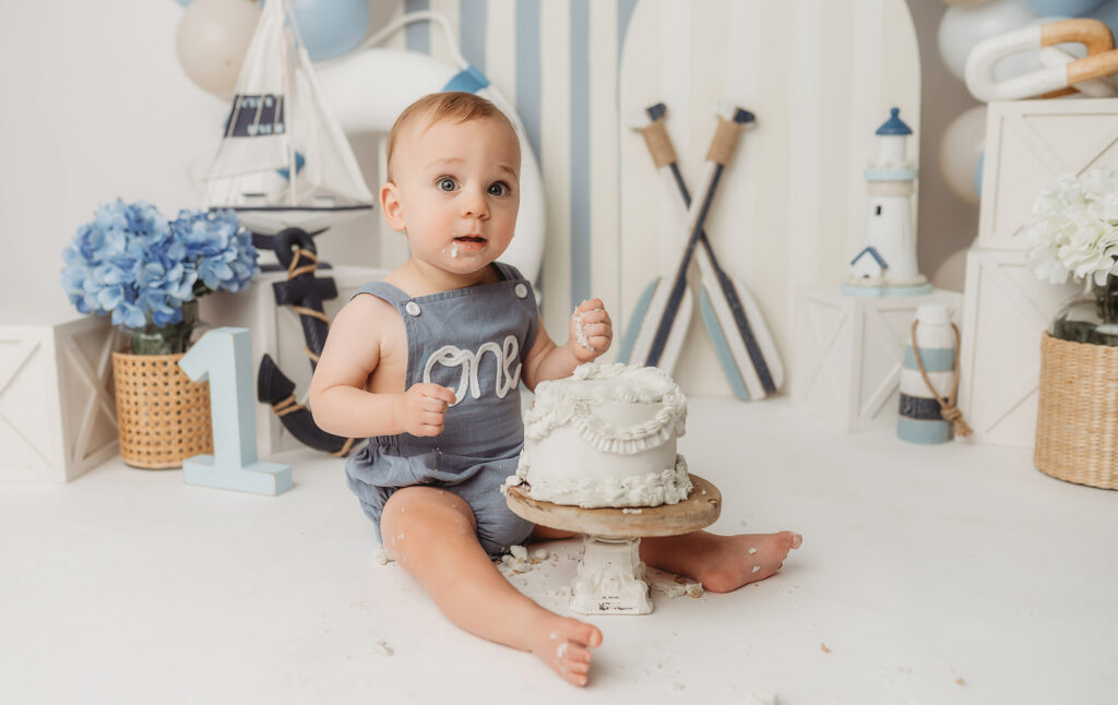 Baby celebrates first birthday with a Milestone, First Birthday Cake Smash Photoshoot at Holy City Babies Portrait Studio in Charleston, SC.