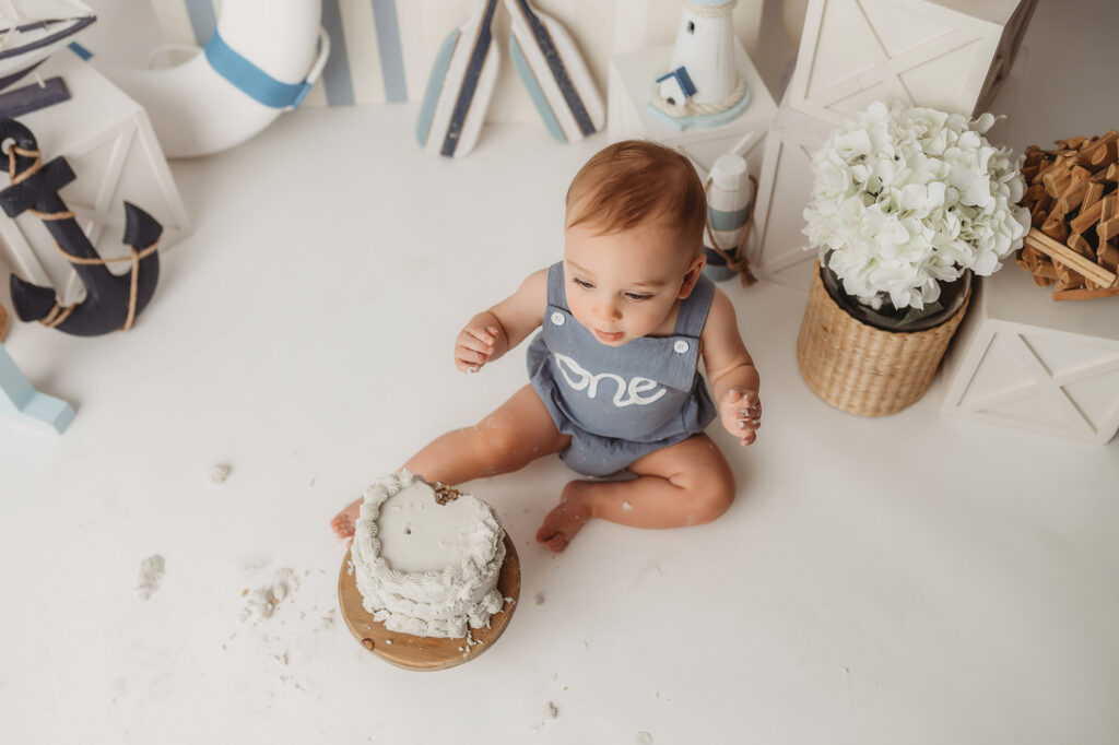 Baby celebrates first birthday with a Milestone, First Birthday Cake Smash Photoshoot at Holy City Babies Portrait Studio in Charleston, SC.