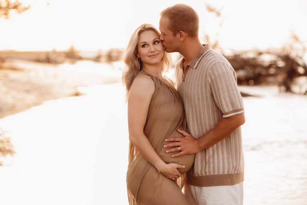 Expectant parents pose for Maternity Portraits at Folly Beach in Charleston, SC.