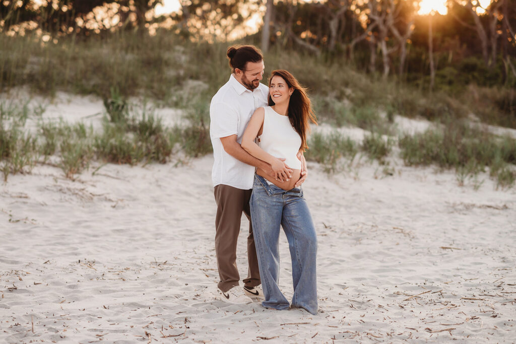 Expectant Parents pose for Maternity Photos on Folly beach in Charleston, SC.