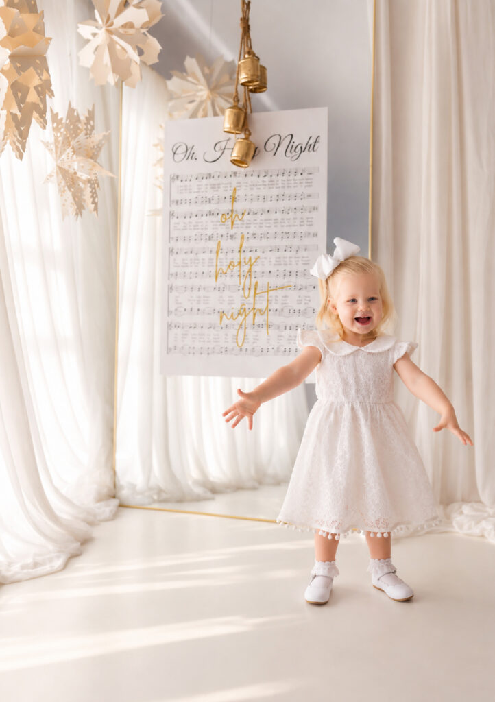 Toddler smiles at the camera during Christmas Mini Session at Holy City Babies Portrait Studio in Charleston, SC. 