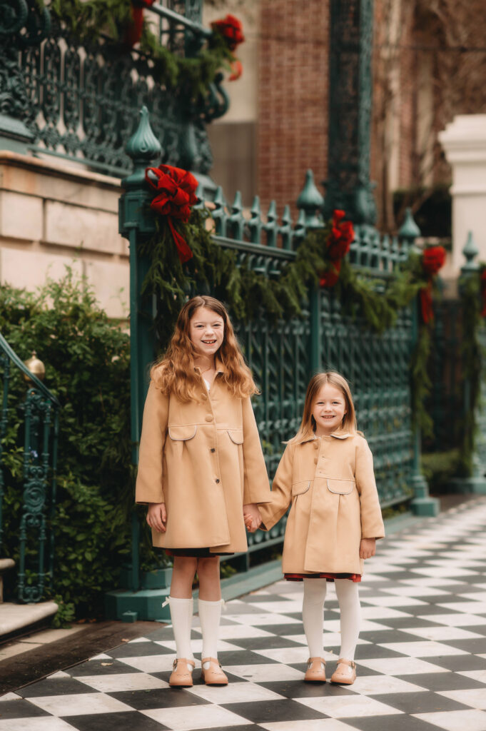 Little girls hold hands during Downtown Charleston Holiday Mini Sessions. 