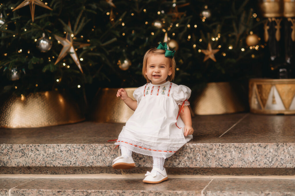 Toddler sits on the steps at Charleston Place during Downtown Charleston Holiday Mini Sessions.